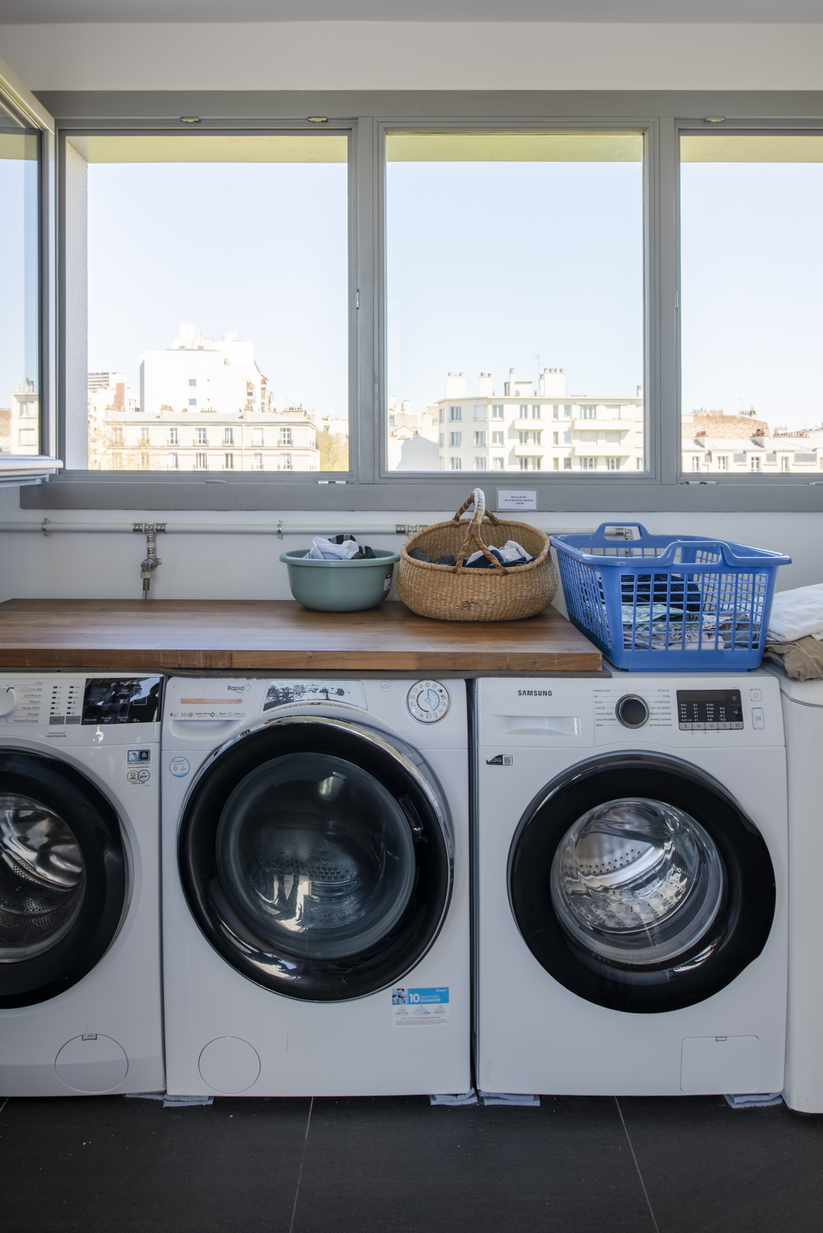Buanderie commune d'UTOP, machines à laver et vue sur Paris