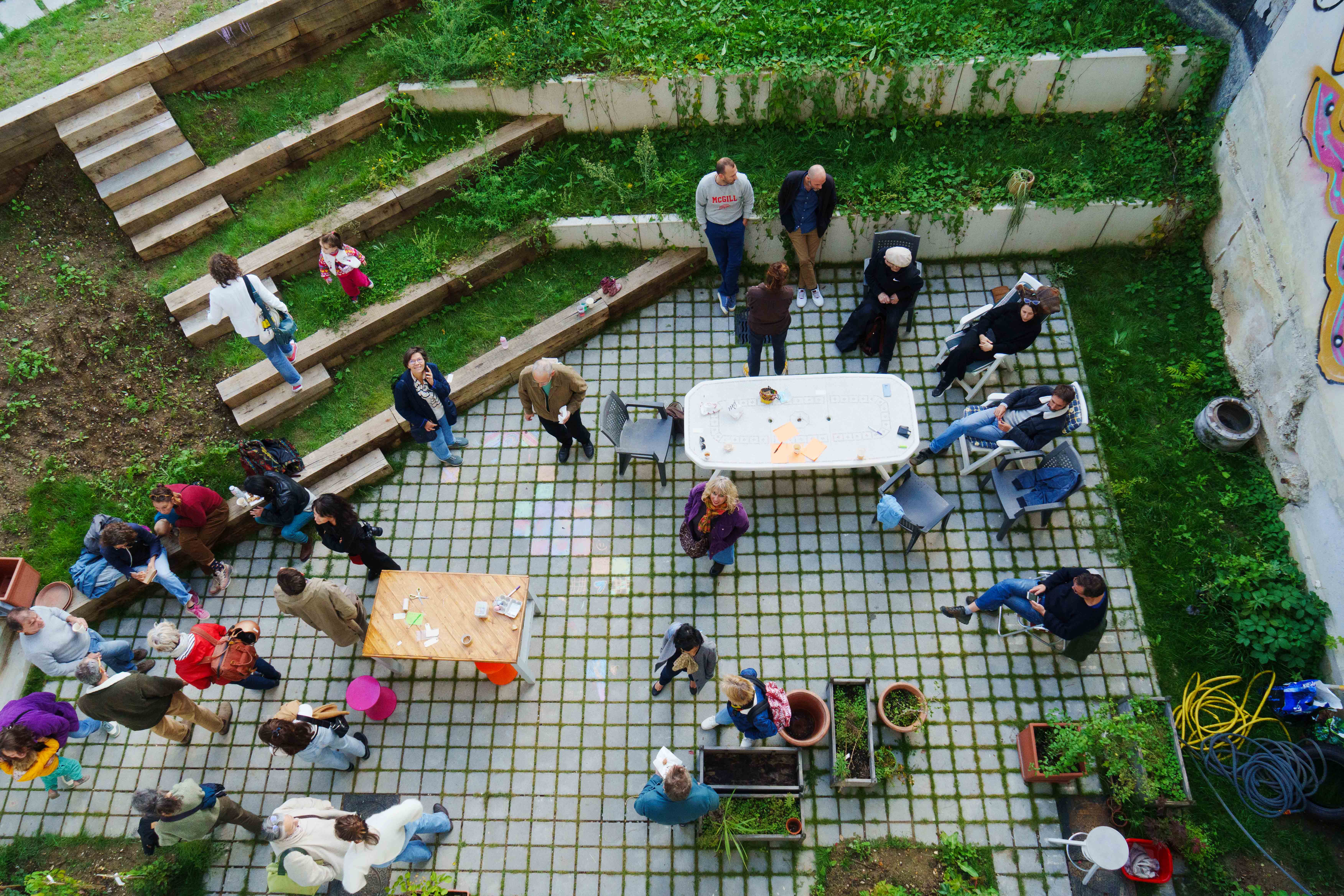 Le jardin d'UTOP vu d'en haut, gradins en bois, rassemblement d'habitant·es