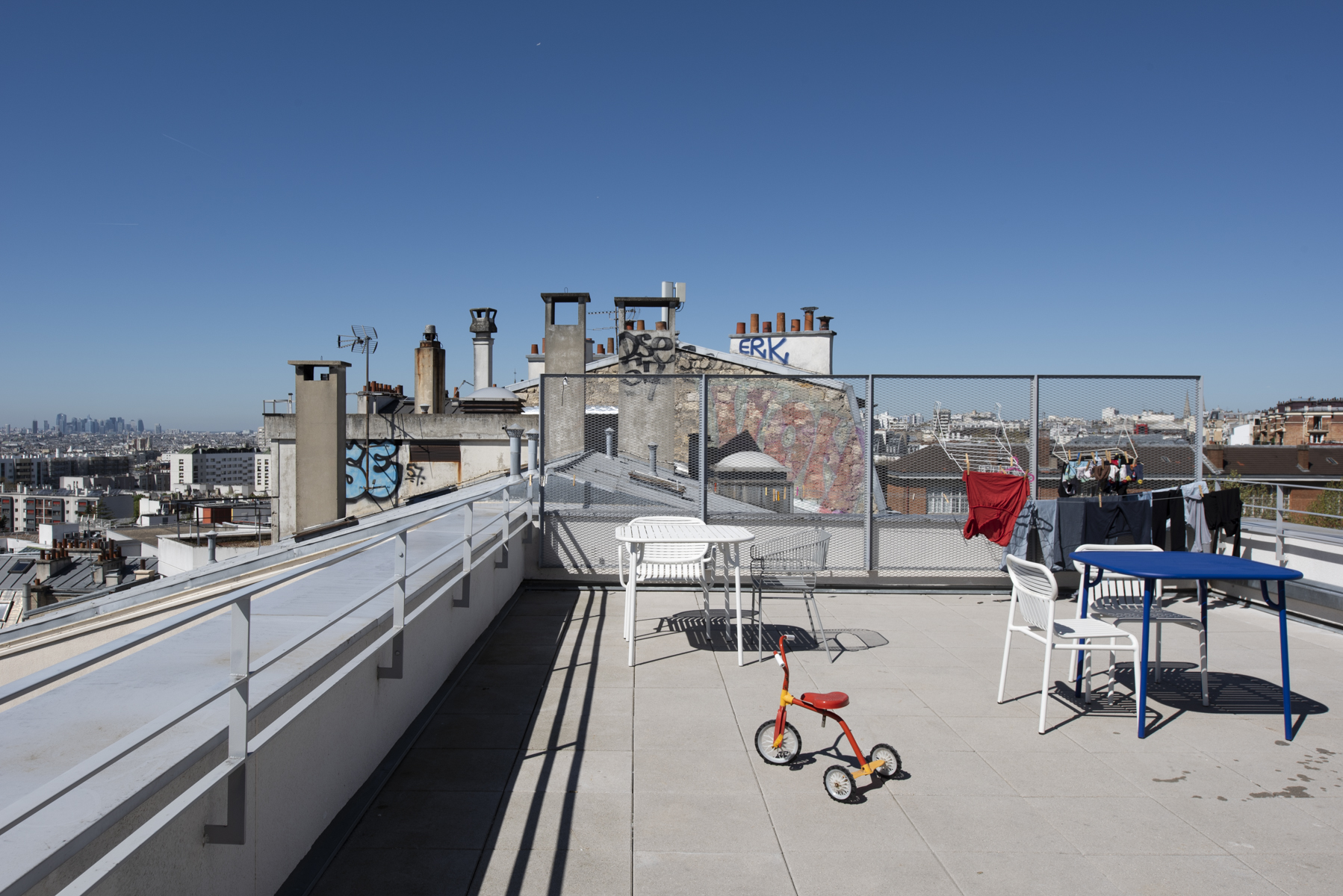Terrasse commune d'UTOP, toits de Paris et tricycle